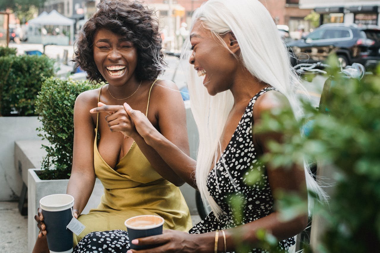 Women Holding Disposable Cups Laughing